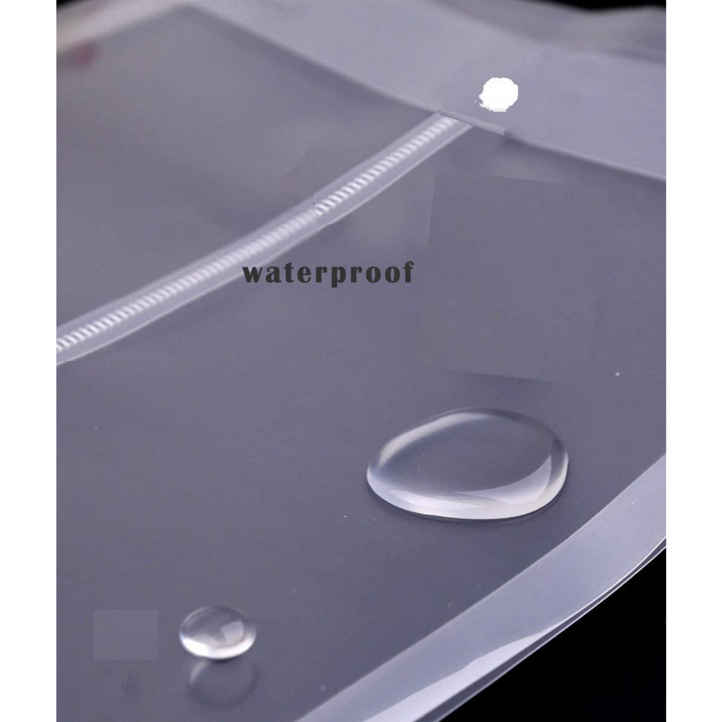 Close-up of a transparent waterproof plastic sheet with water droplets beading on the surface and the word 'waterproof' written on it